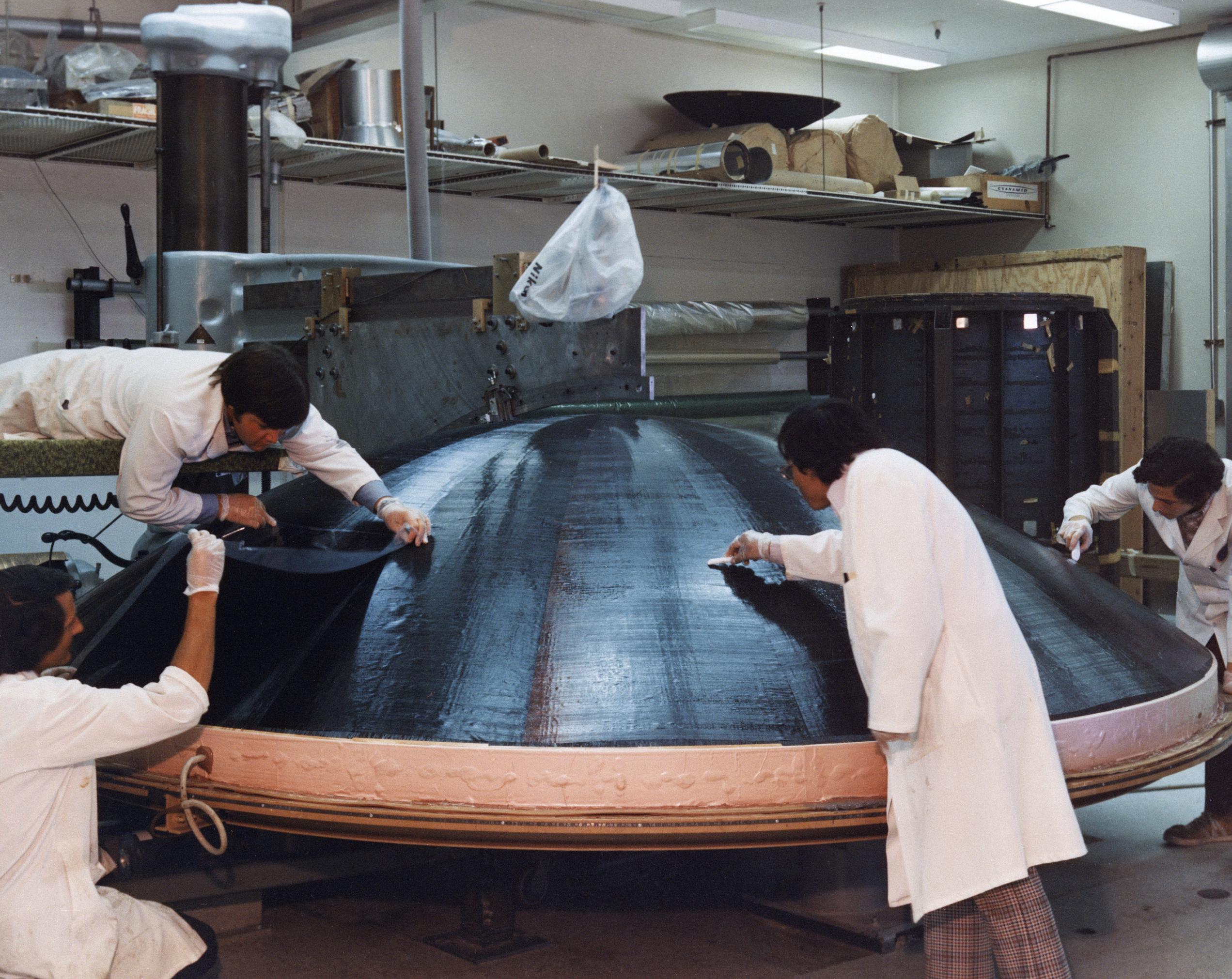 Engineers working on the construction of a large, dish-shaped Voyager high-gain antenna