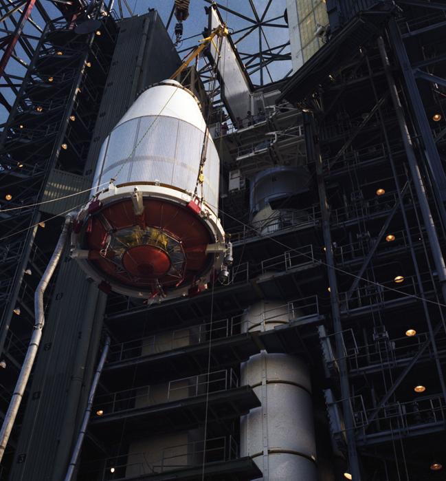 The Voyager 2 spacecraft, encapsulated within its payload fairing, being hoisted upward for attachment to its launch vehicle