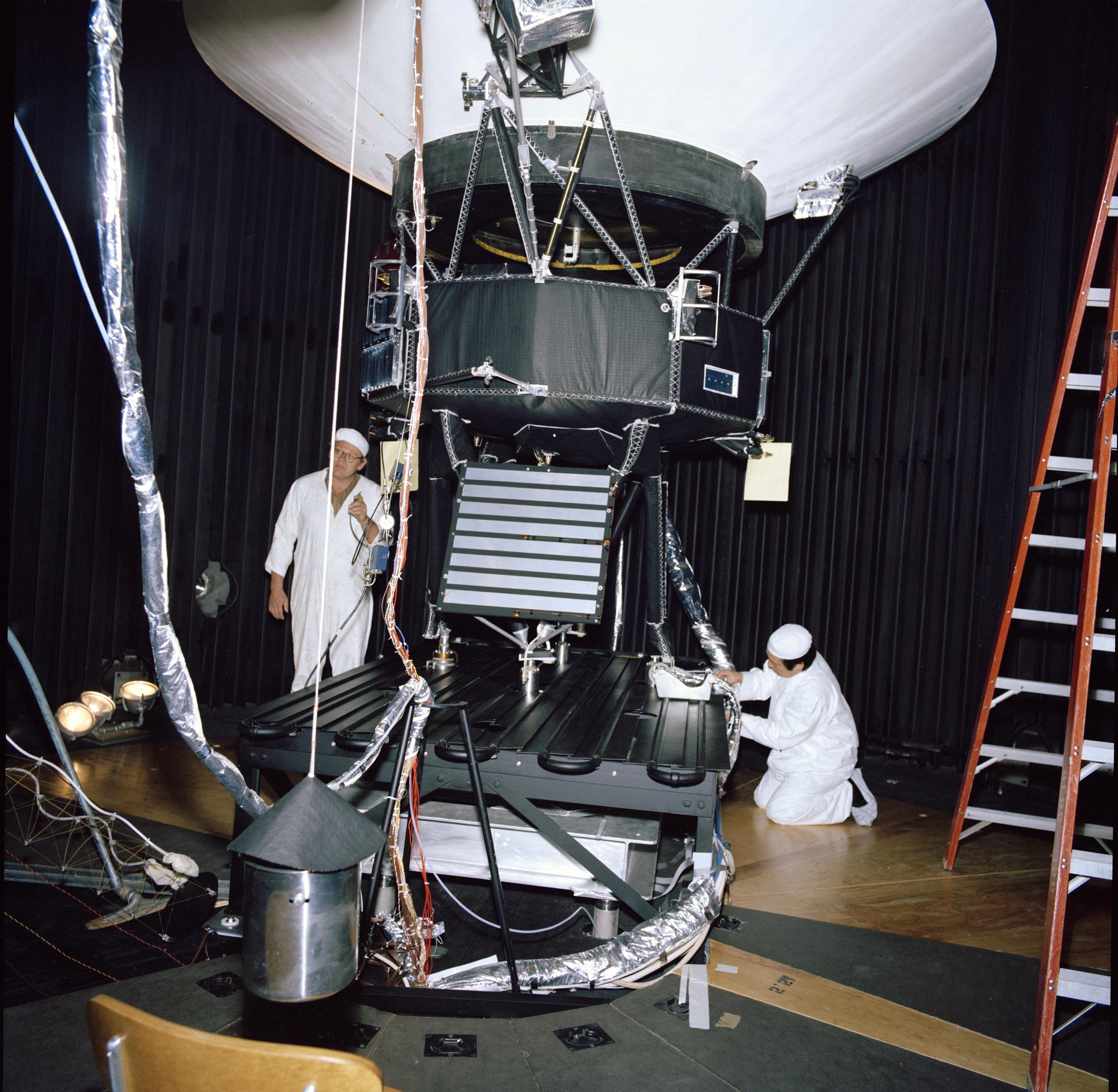 Voyager proof test model with engineers in the 25-foot space simulator chamber at NASA's Jet Propulsion Laboratory