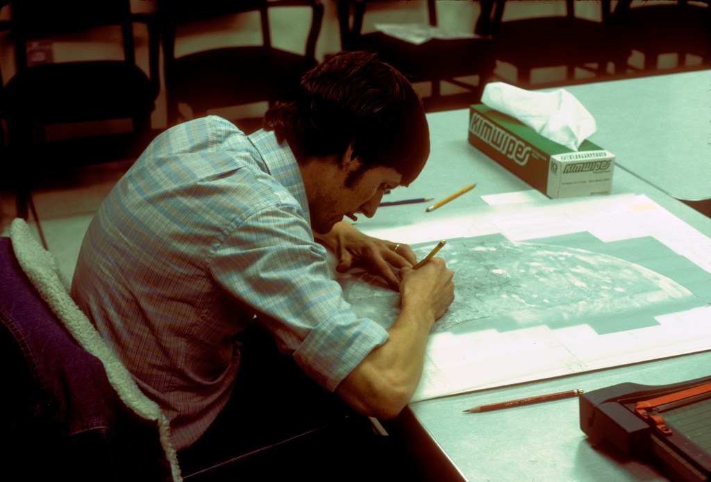 A man sitting at a desk looking at a map