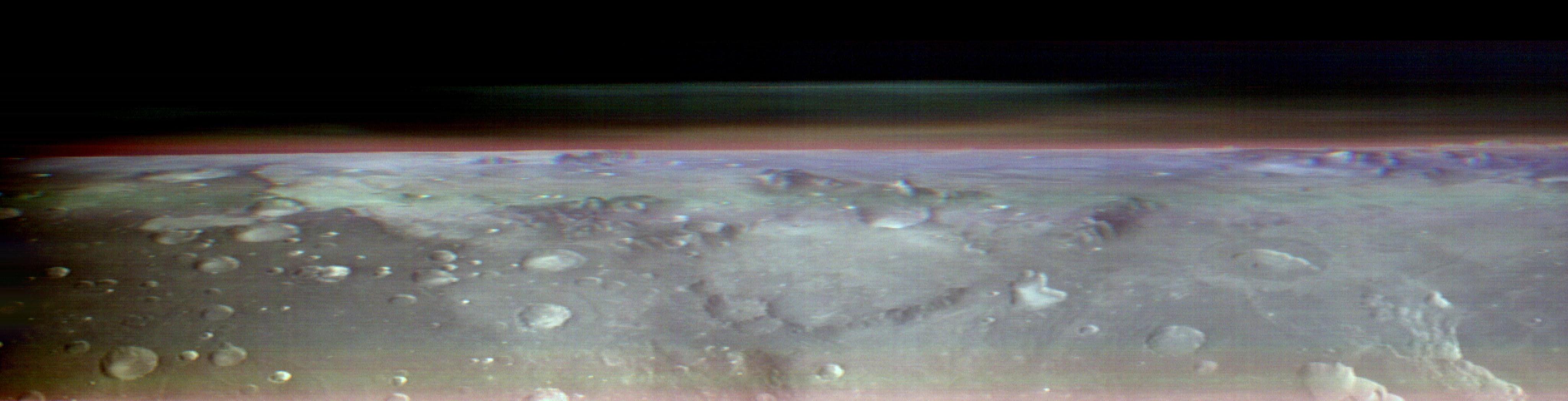 Water-ice (blue) n' dust (red) up in tha atmosphere of Mars above tha cratered Martian surface as viewed from orbit by tha THEMIS camera (false-color composite image).