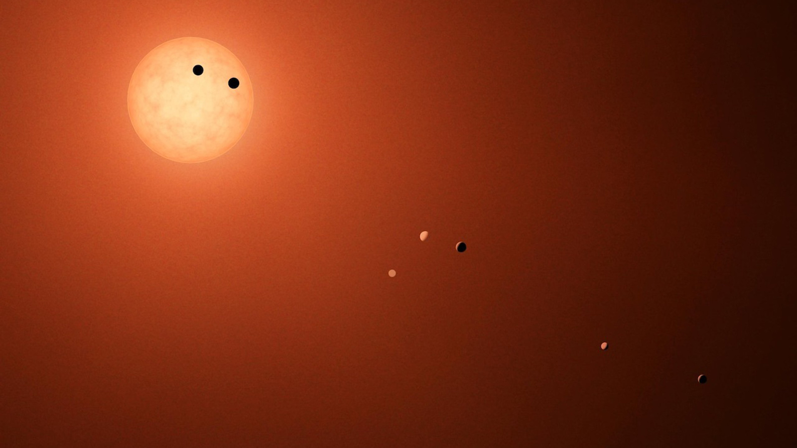 Artist's concept shows the red-dwarf star, TRAPPIST-1, at the upper left, with two large dots on the face of the disk representing transiting planets; five more planets are shown at varying positions descending toward the lower right as they orbit the star. Artist's concept shows the TRAPPIST-1 planets as they might be seen from Earth using an extremely powerful - and fictional - telescope. Credit: NASA/JPL-Caltech