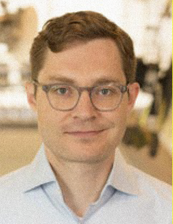 Dmitry Vorobiev headshot, male, reddish brown hair, glasses, smirk, white collared shirt.