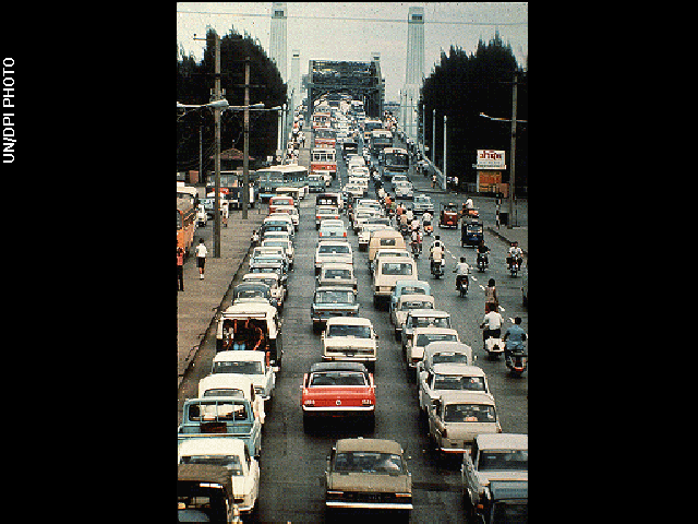 A busy street packed with five lanes of vehicles