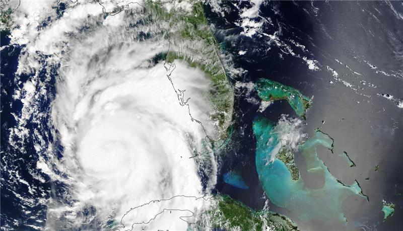 Hurricane Idalia as photographed by NASA's Terra satellite in August 2023. The swirling mass of the hurricane passes over some land masses and the ocean.