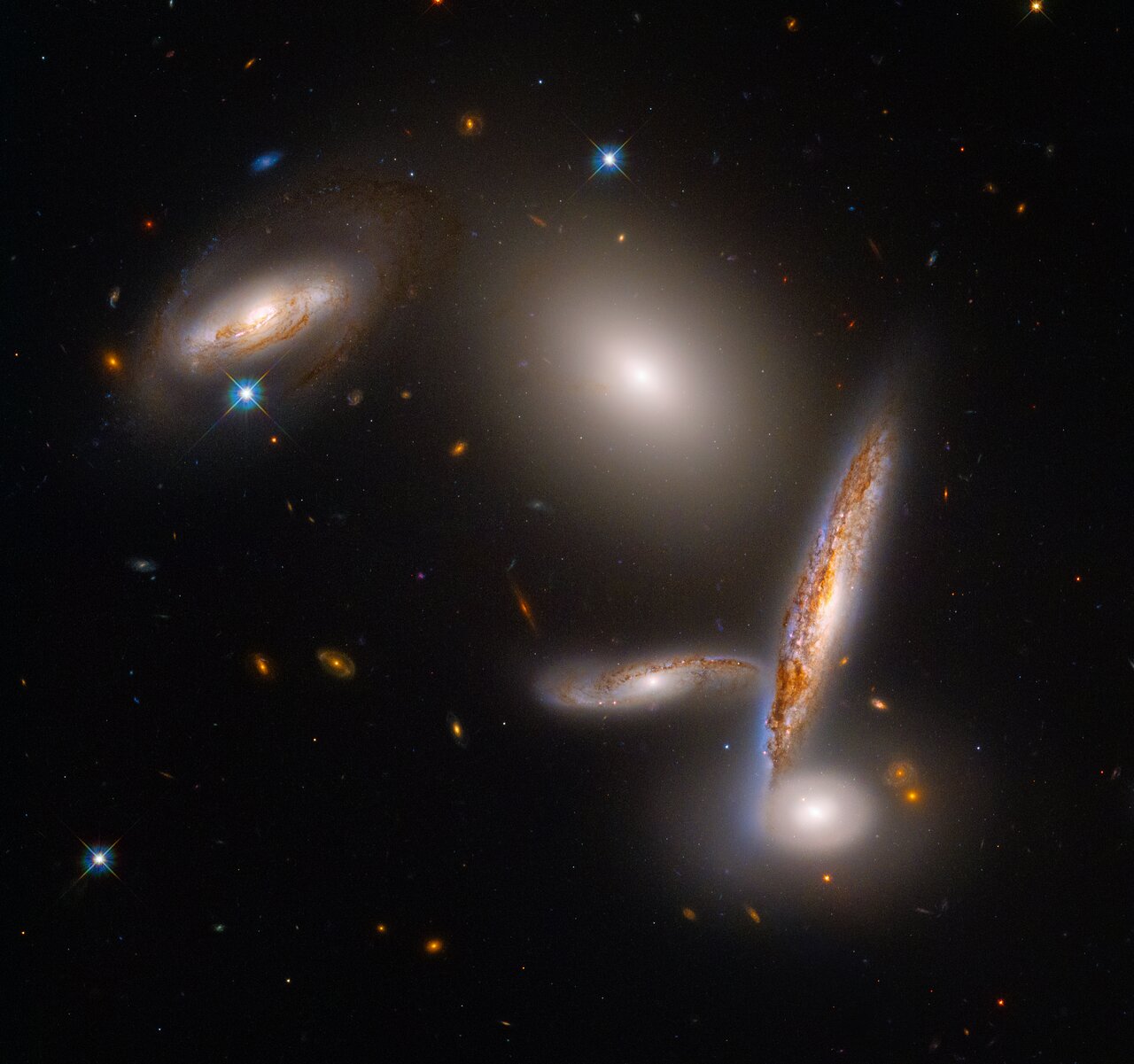 Five galaxies, two toward the upper right and top center, three clustered together in the lower right.