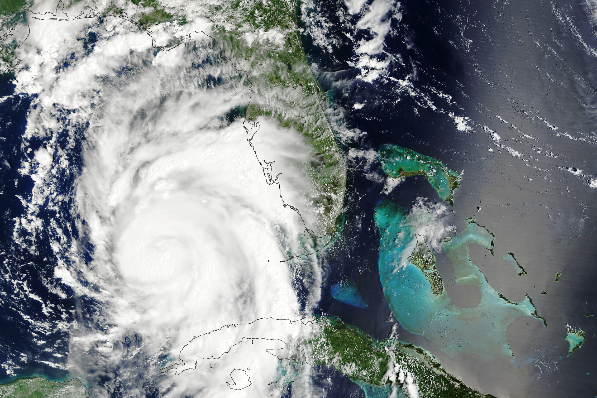 Hurricane Idalia as photographed by NASA's Terra satellite in August 2023. The swirling mass of the hurricane passes over some land masses and the ocean.