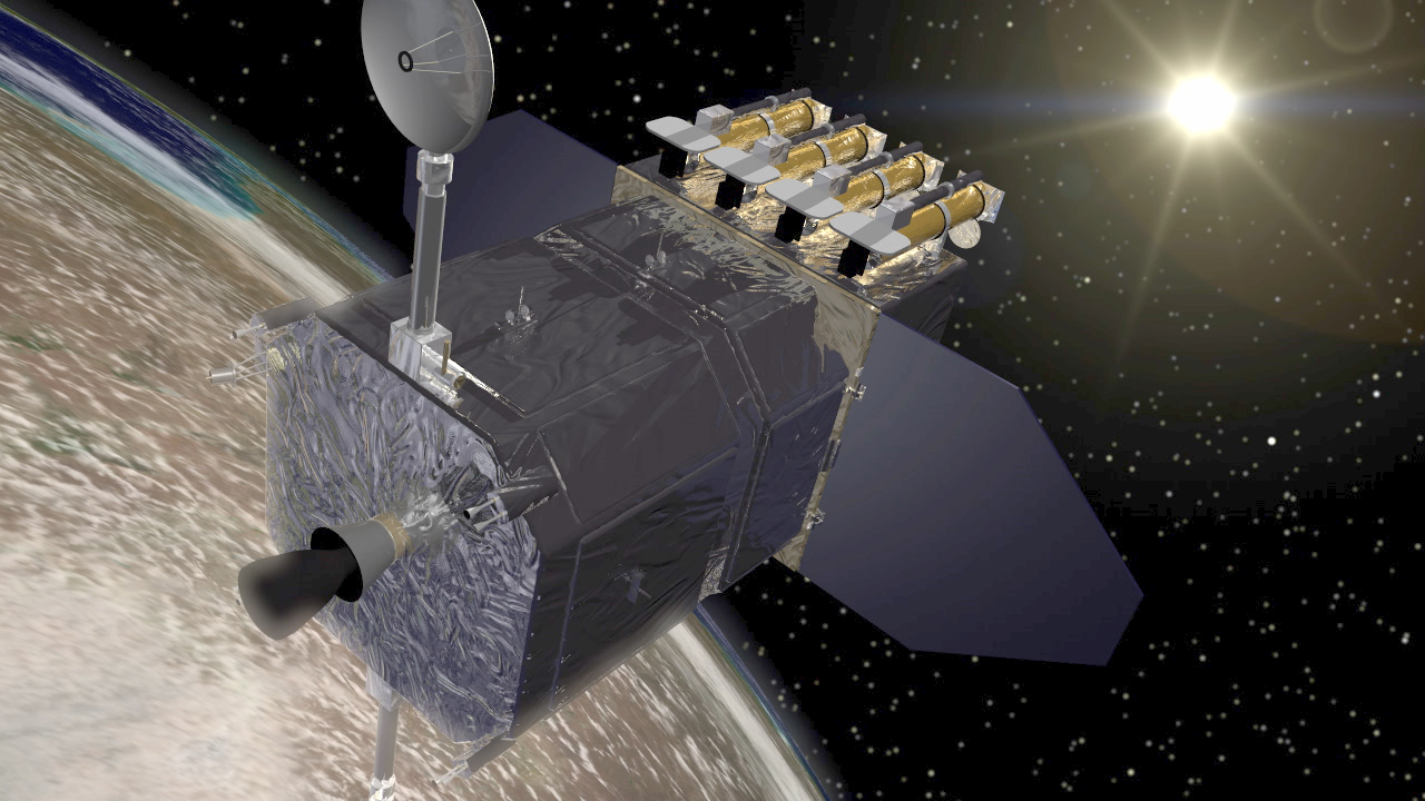 The Solar Dynamics Observatory spacecraft, like a silver rectangular box, with an antennae attached to the top. On the back are 3 cyclindrical objects and there is a large flat panel protruding from the left and right on the back.