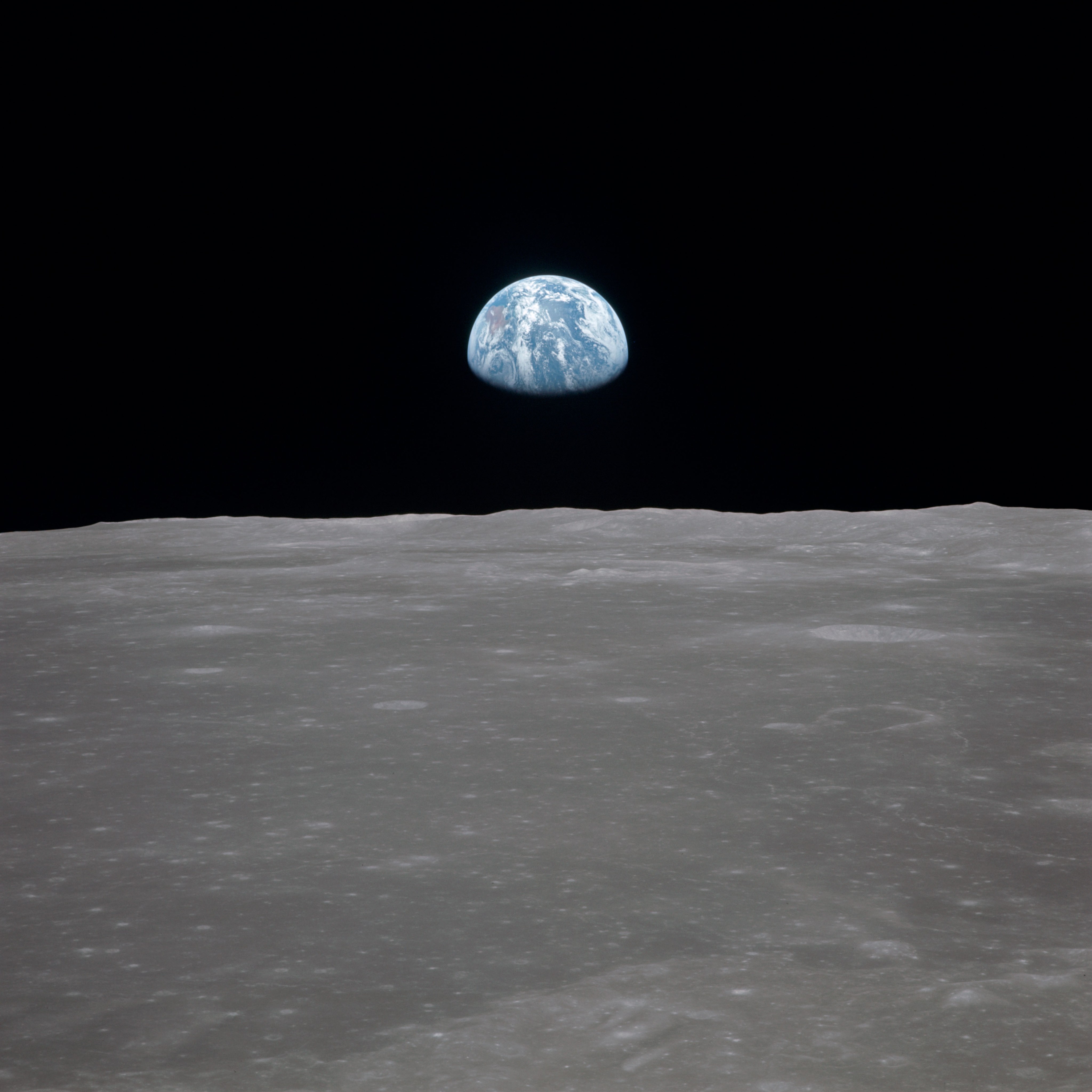 View of Moon limb with Earth on the horizon,Mare Smythii Region. Earth rise. This image was taken before separation of the LM and the Command Module during Apollo 11 Mission.
