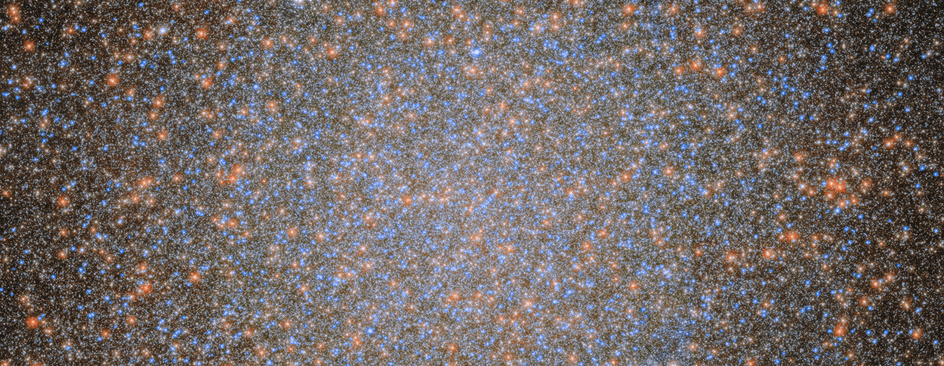 An image of the globular cluster Omega Centauri, a collection of myriad stars colored red, white, and blue on the black background of space.