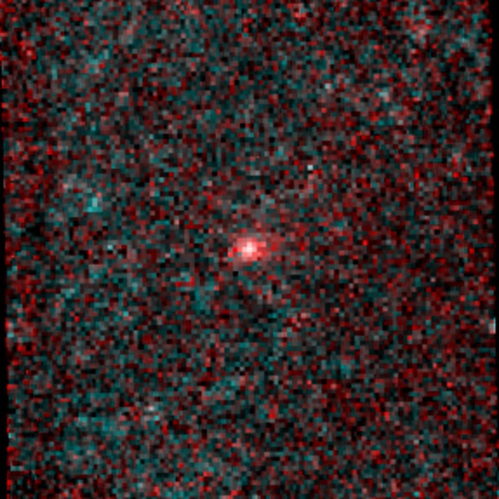 A heavily pixelated image composed of a multitude of tiny green and red squares features a bright white dot at the center, surrounded by a halo of bright pink pixels.