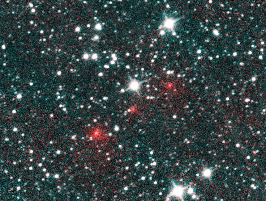 Against a fuzzy star field of bright white points of light, three glowing red dots march across the frame at center, heading from lower left toward upper right.