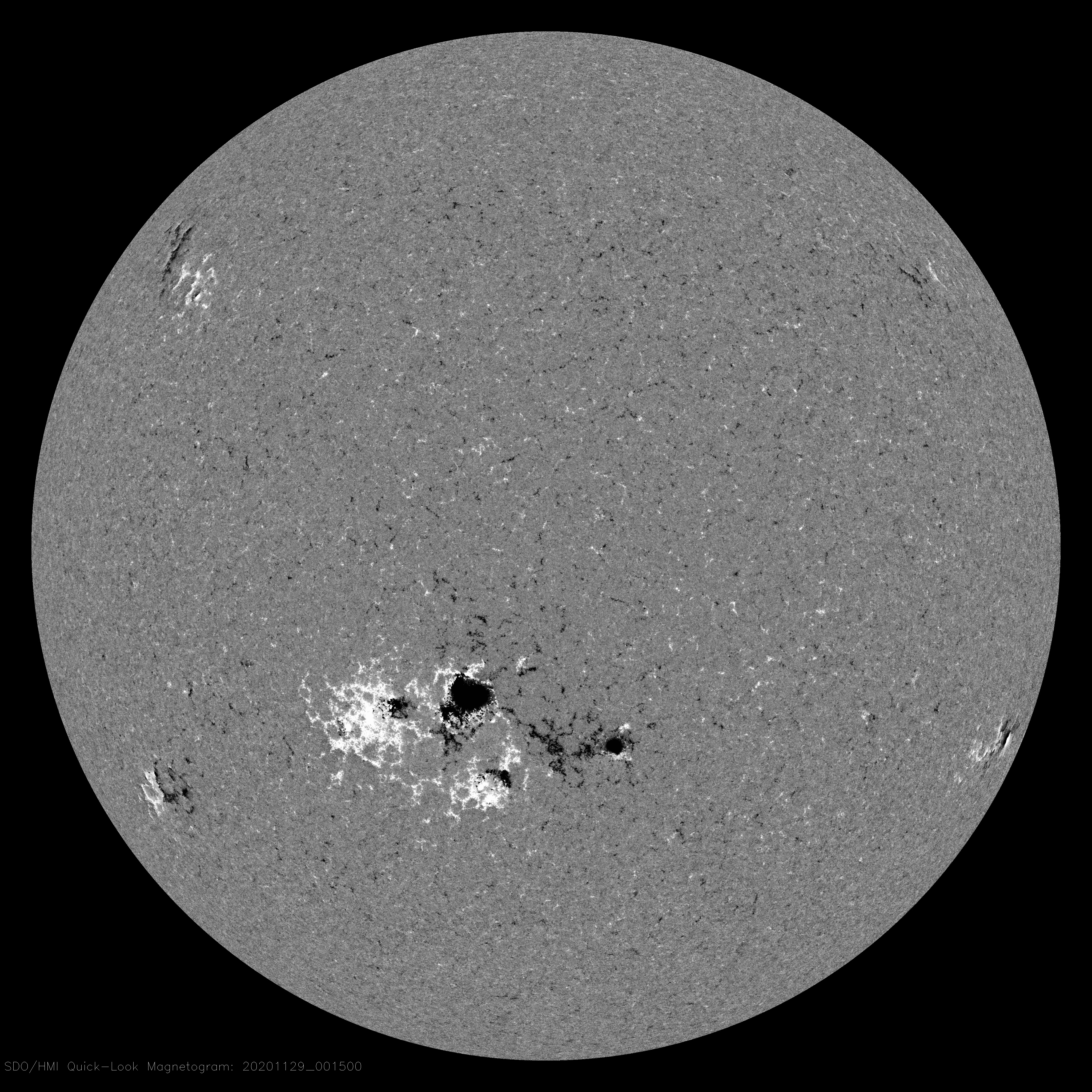 The Sun, shown in gray. Toward the center and slightly down on the star are splotches in black, surrounded by white that stretches out a little farther on the Sun. These are sunspots.