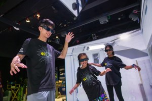 A boy and a girl wearing special virtual reality glasses appear to be floating on the International Space Station.