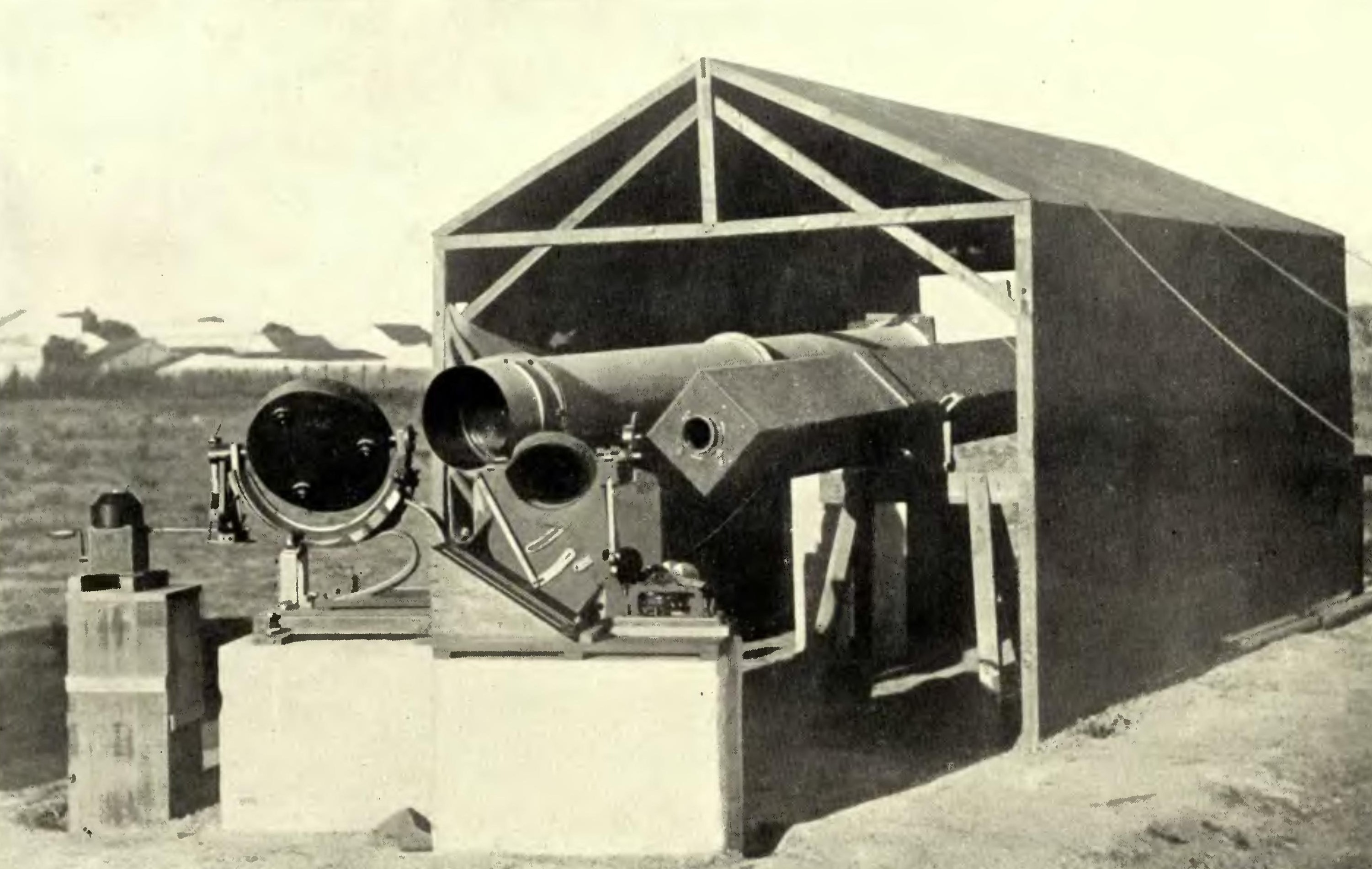 A sepia-toned photo of two telescopes in a shed.