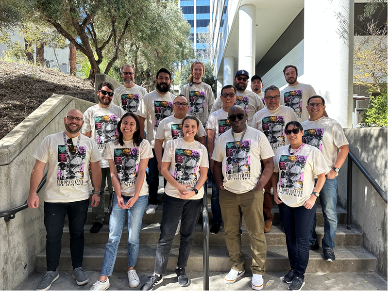 Several people wearing matching t-shirts and standing on some steps at JPL.