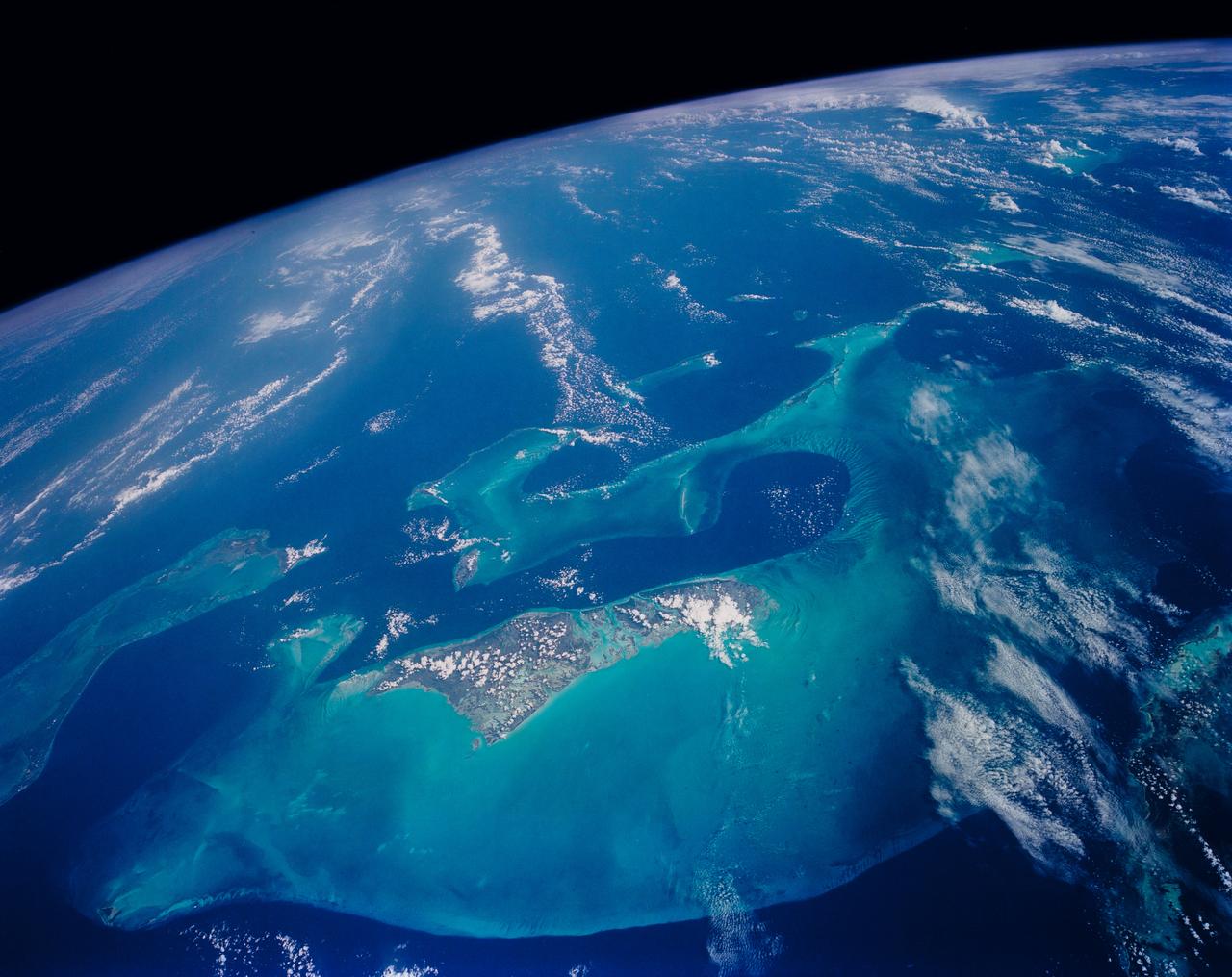 The ocean with light cloud cover as seen from space.