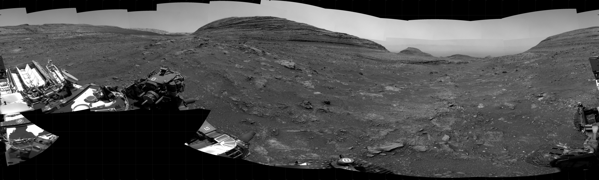 A grayscale panoramic image of the Martian surface shows booth sky and ground.