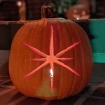 View of an illuminated jack-o'-lantern style pumpkin carved with an image of an 8 pointed star.