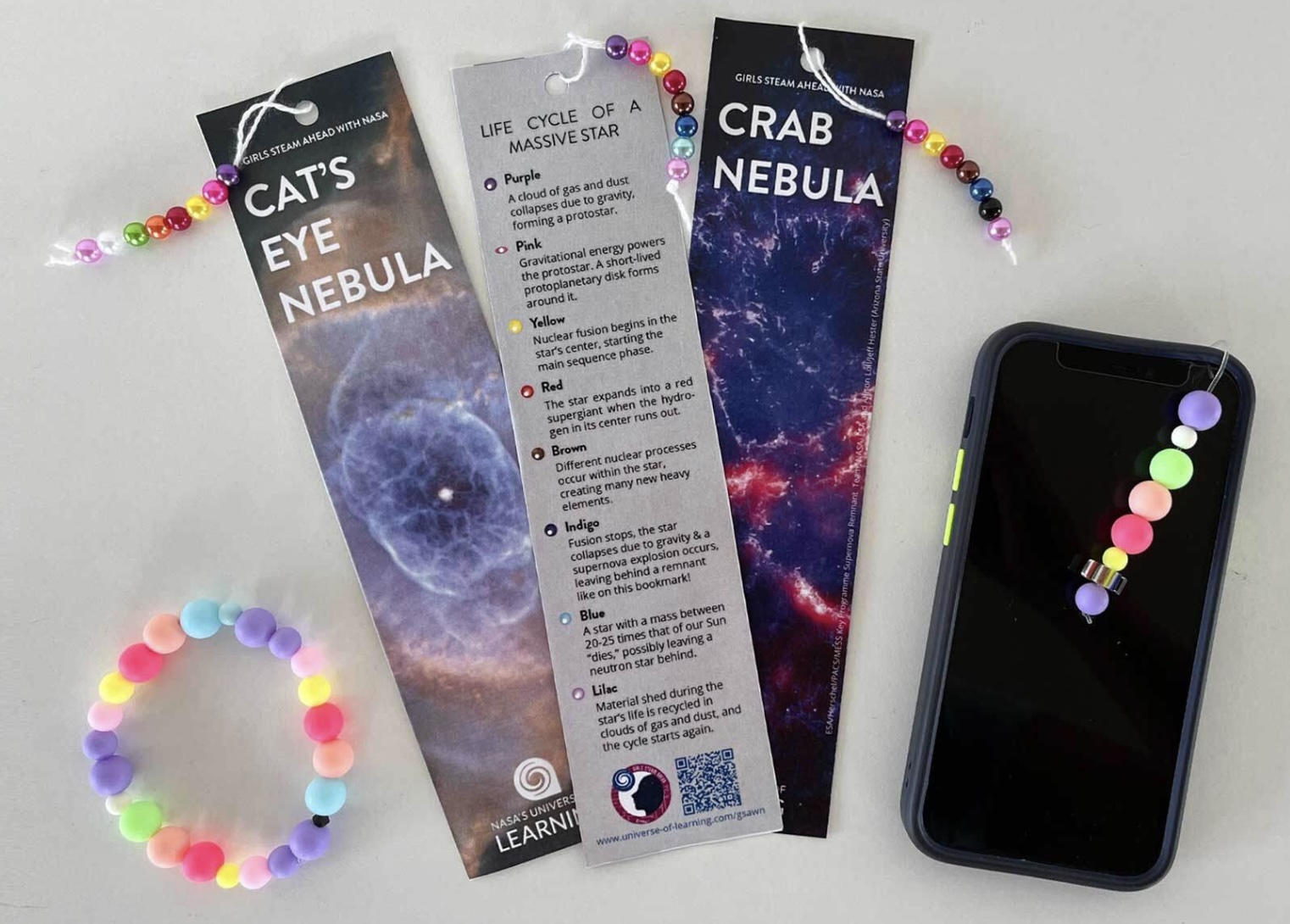 A set of bookmarks, a colorful bracelet and a phone.