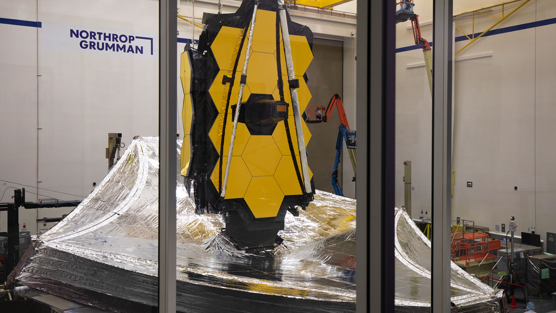 Full view of Webb with sunshield and mirrors with two mirror wings folded in the Northrop Grumman Clean Room.