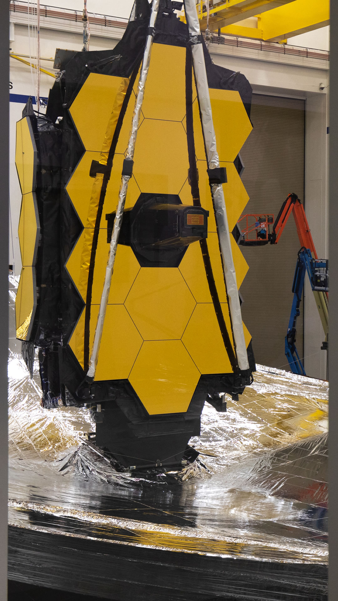 Vertical view of Webb with sunshield and mirrors with two mirror wings folded in the Northrop Grumman Clean Room.