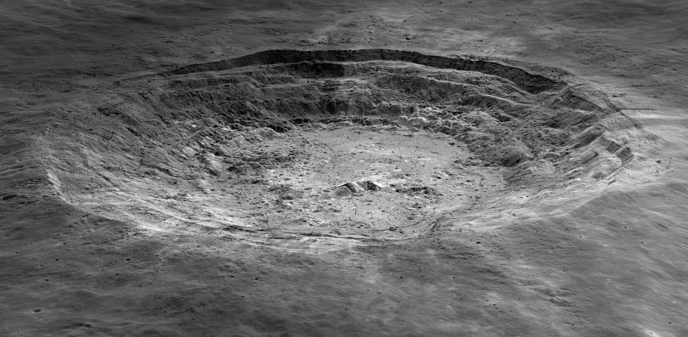 Aristarchus crater has slumping terraced walls and peaks in its center. The terrain looks rubble-covered and pitted.