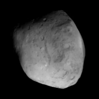 An oblong-shaped grey asteroid in the blackness of space.