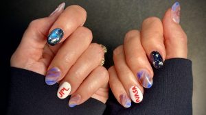 Fingernails painted in colors symbolic of the Europa Clipper mission and with NASA and JPL on some fingers.