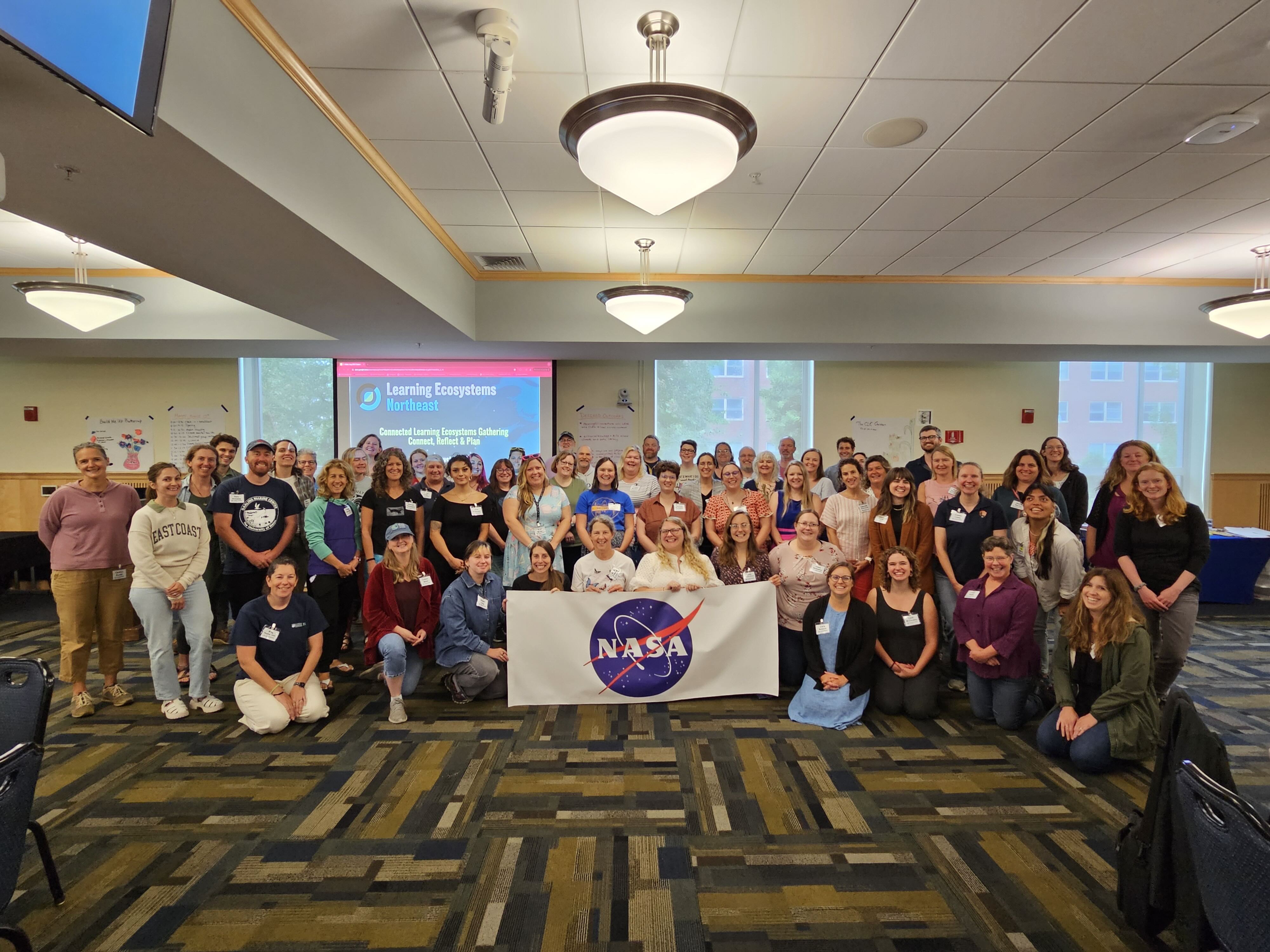 A group photo of all the organizers and participating educators in front of the NASA logo