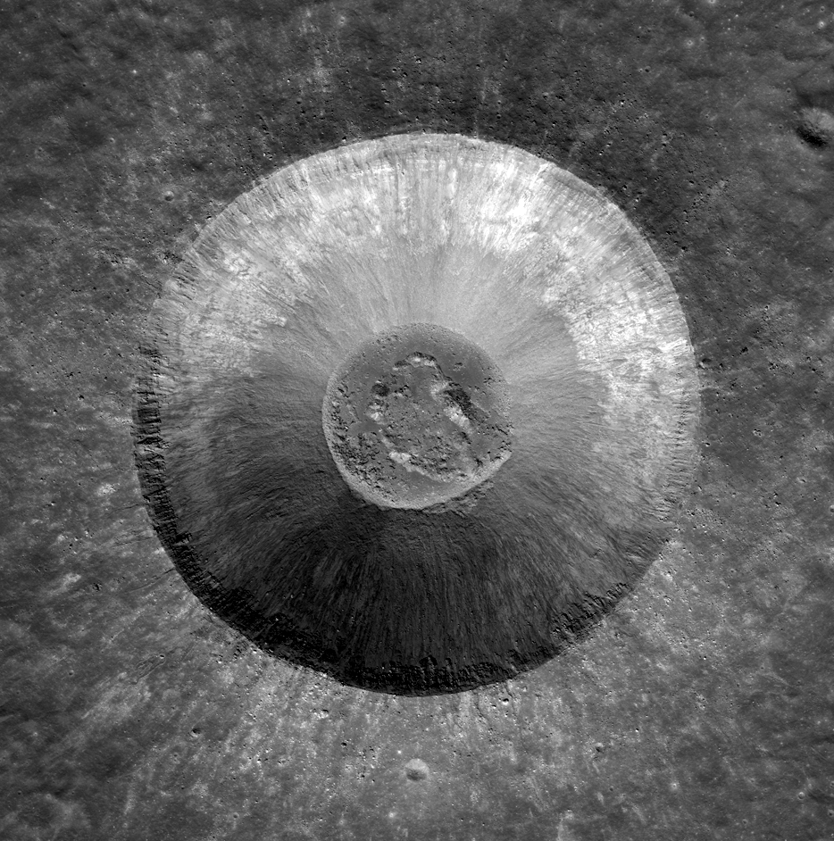 An almost perfectly round crater with ejecta radiating outward and a round circle of debris in the center.