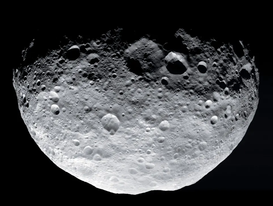 A half-lit view of large asteroid Vesta. Numerous craters are clearly visible on the surface.