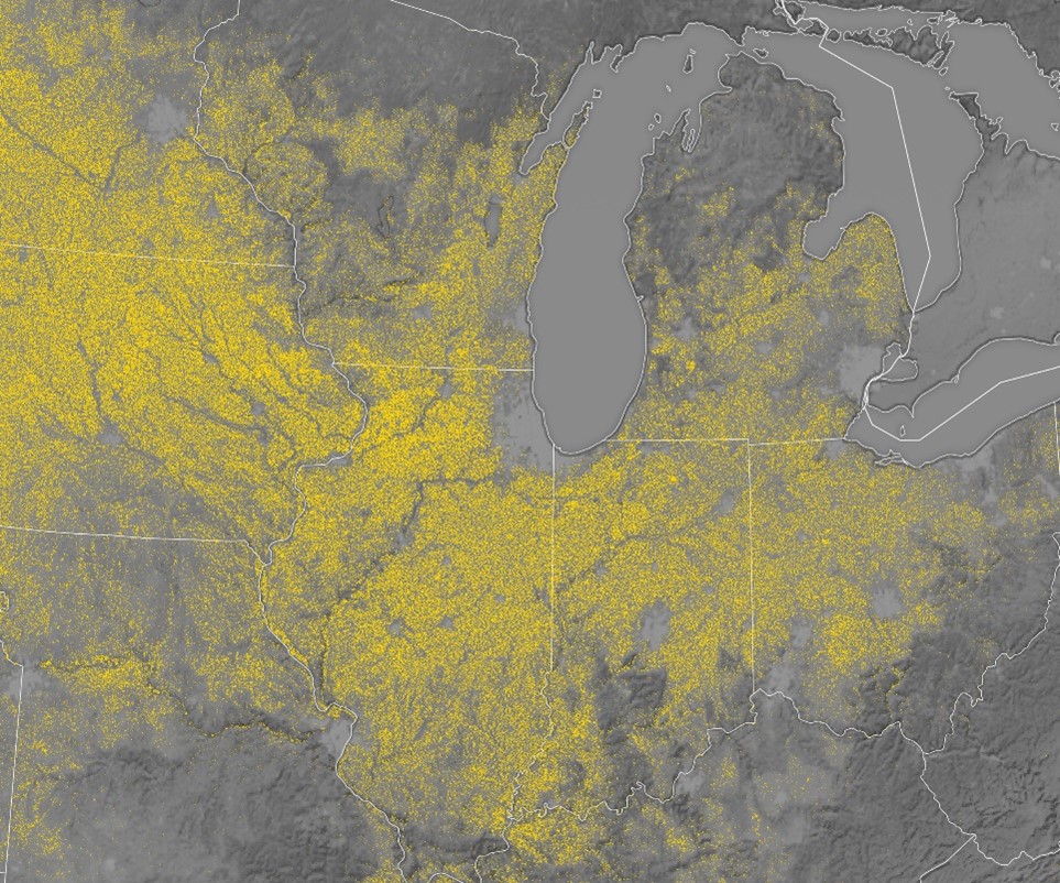 Map of U.S. Midwest showing corn cultivation in yellow dots against gray background, with several Great Lakes visible.