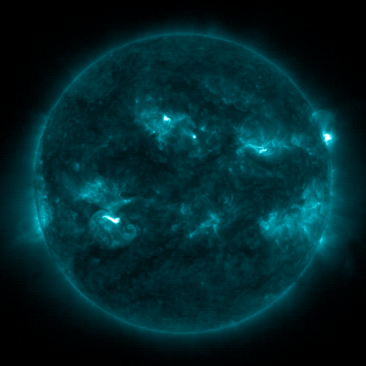The Sun, shown in blue, against a black background. In several areas on the Sun, small flashes appear sporadically. On the right, multiple bright flashes burst from one area.