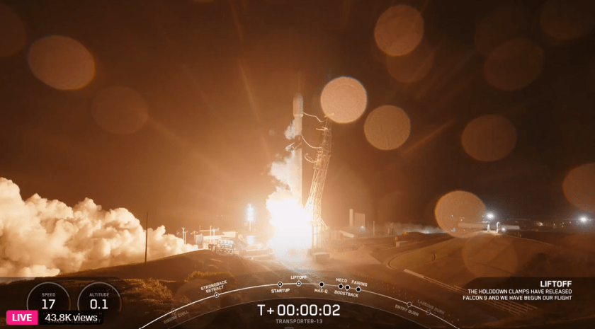 A rocket lifts off from a launch pad at night