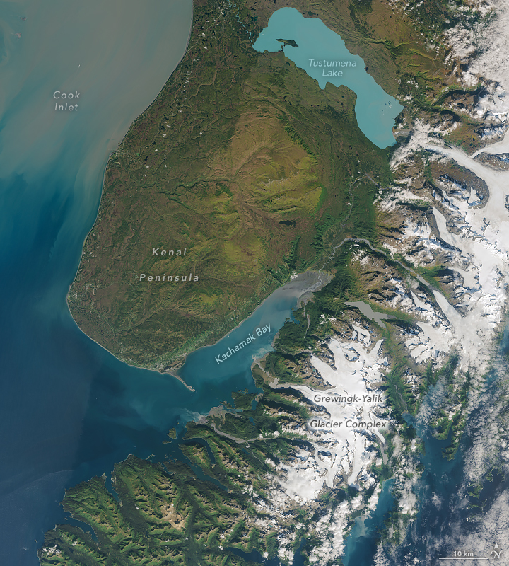 This is a wider view of Kachemak Bay but this version shows darker blue ocean waters to the west in Cook Inlet. More glaciers and ice are visible to the east of the bay as well.
