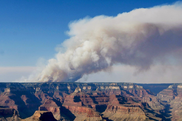 A photograph, taken from the South Rim by National Park Service staff, shows a tall plume of smoke rising over the North Rim on July 11, 2025.