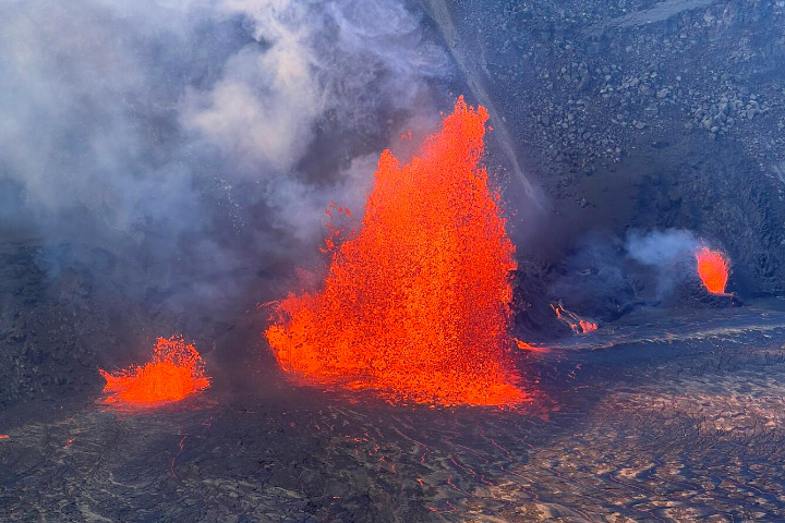Photograph of a red fountain of lava billowing from Kaluapele, Kilauea's summit caldera.