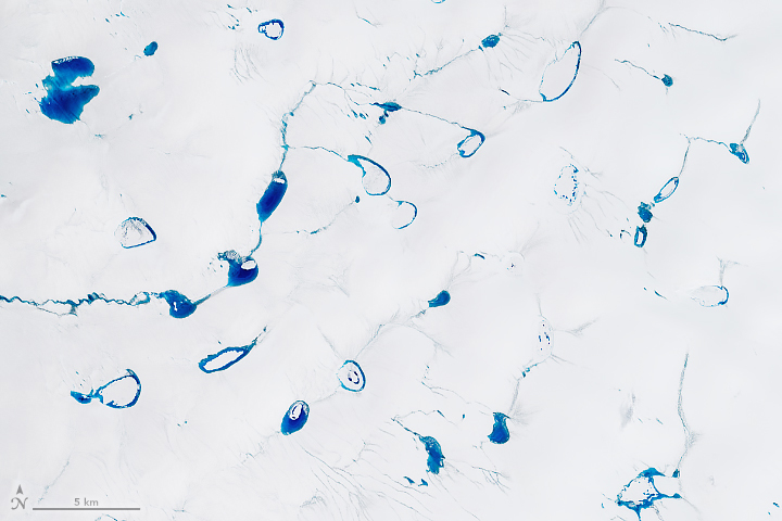 A close-up view of the first scene shows a detailed view of the blue meltwater ponds surrounded by white snow and ice. Thin streams of blue water connect some of the ponds.