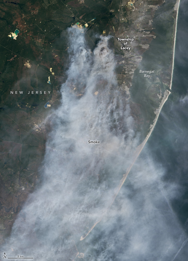 This is a larger version of the natural-color image at the top of the page. In the lower part of the image, additional smoke is visible streaming farther south over sandy beaches and the edge of the Atlantic Ocean.