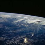 View west into sun glint off the Rio Salado, Saladillo, and Parana Rivers in Argentina. The Space Shuttle nadir is about 28 degrees north latitude and 57 degrees west longitude. The Andes Mountains are barely visible on Earth's limb. Thunderstorms along the eastern edge of the Andes are typical of this time of year (Southern Hemisphere summer), with anvils moving to the east from the core of the storm.